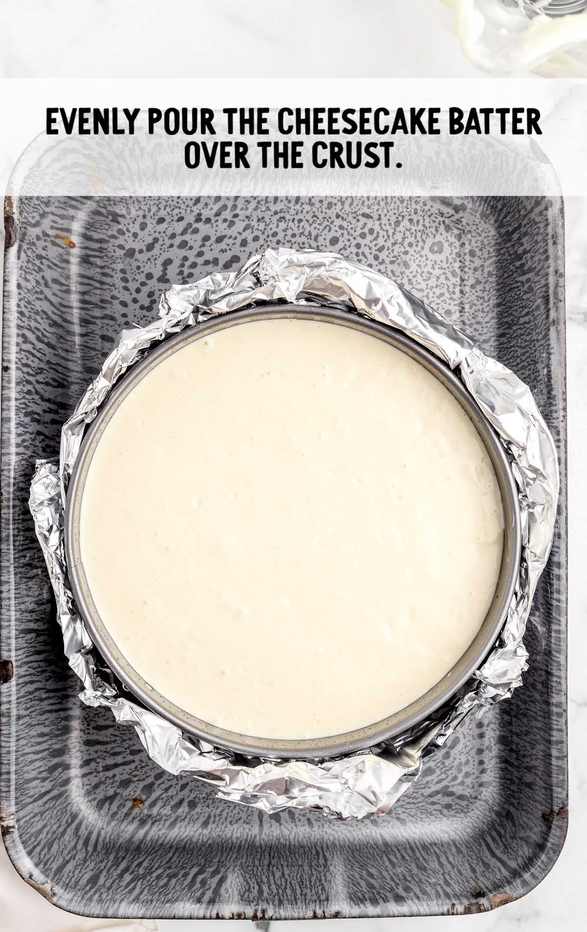 cheesecake batter poured over the crust in a pan