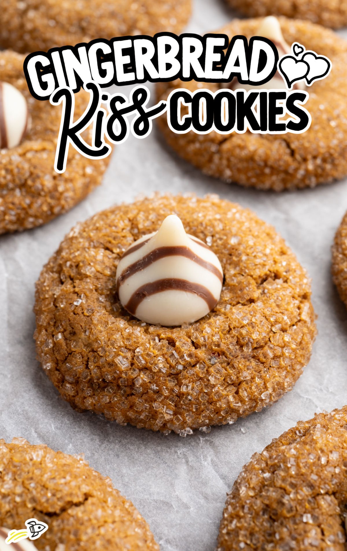 Stacked gingerbread kiss cookies with white-and-chocolate striped Hershey’s Hugs centers.
