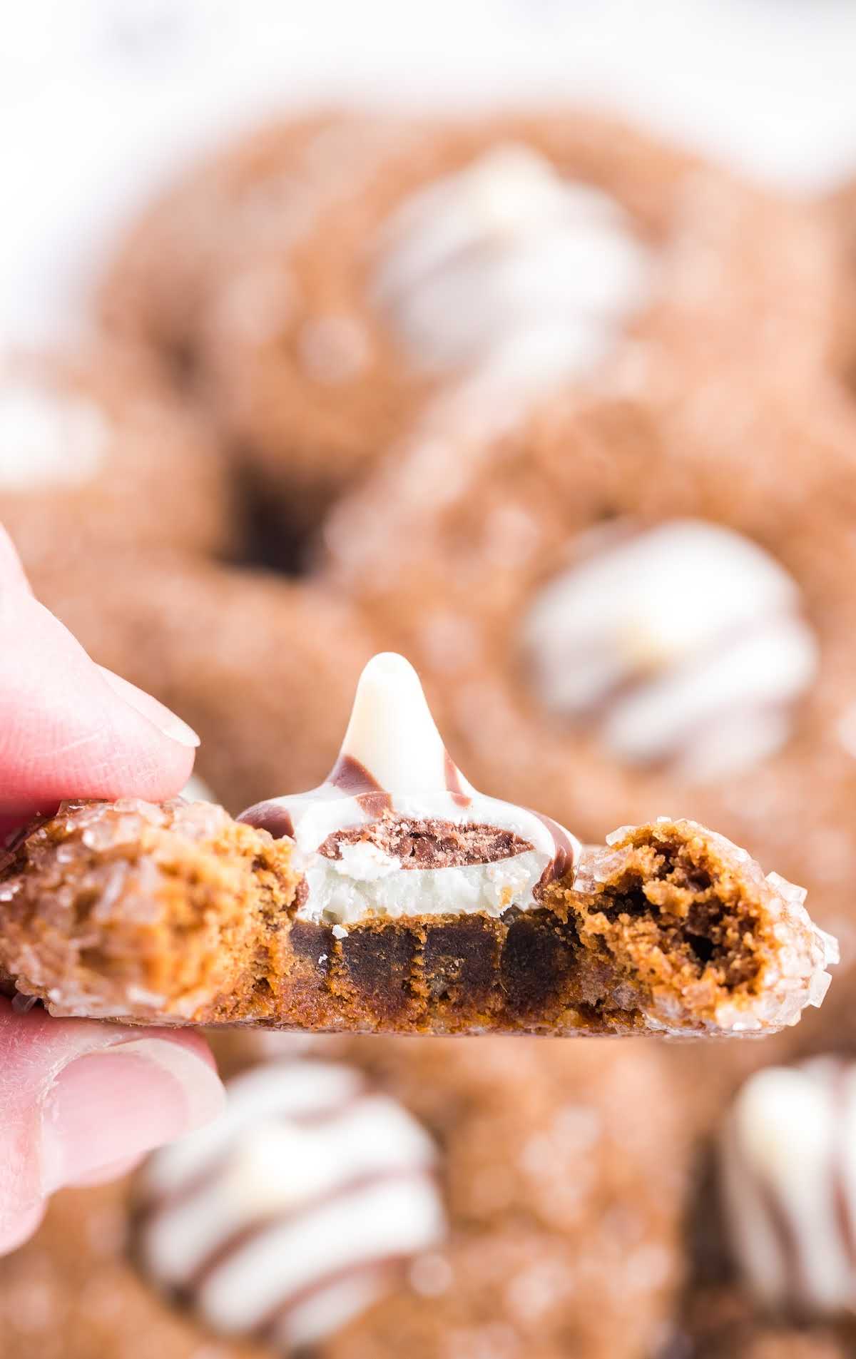 close up shot of a gingerbread kiss cookie with a bite taken out of it