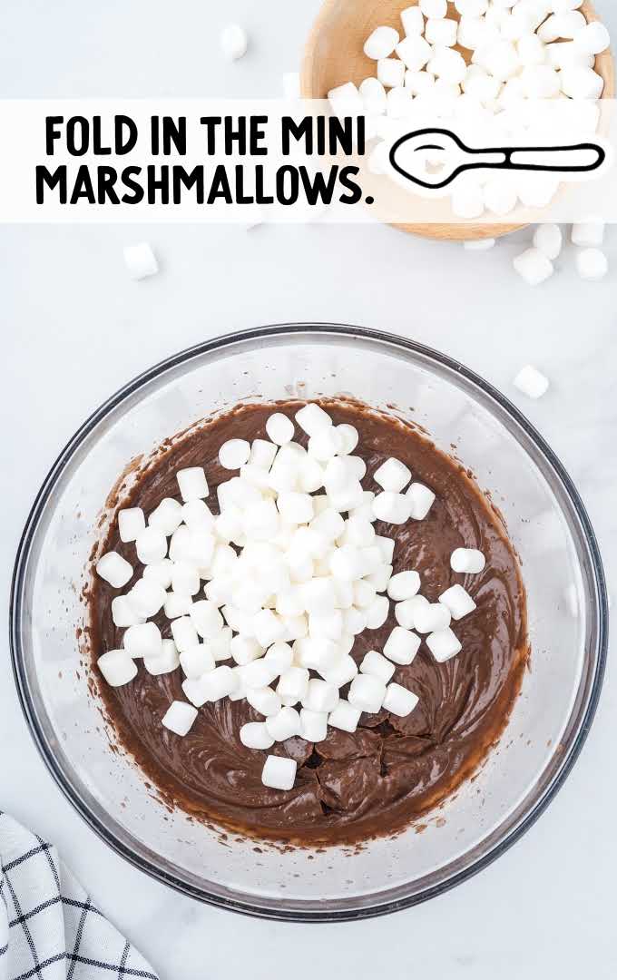 mini marshmallows being added to ingredients in a bowl