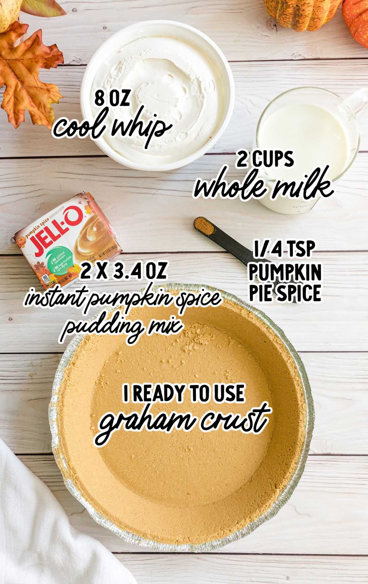 Ingredients for layered pumpkin spice Jello pie arranged on a marble surface, including pumpkin puree, gelatin, and whipped topping.