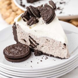 close up shot of a slice of no bake oreo cheesecake topped with crushed Oreos