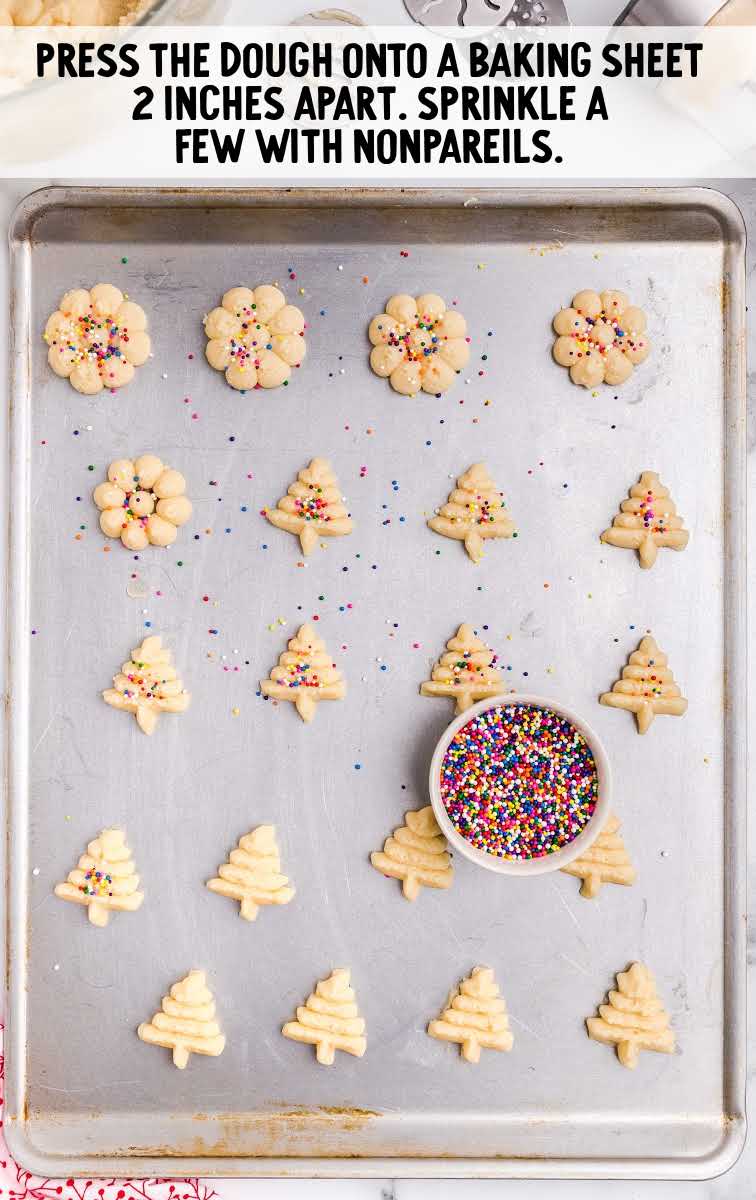 sprinkles placed on top of cookie dough on a baking sheet