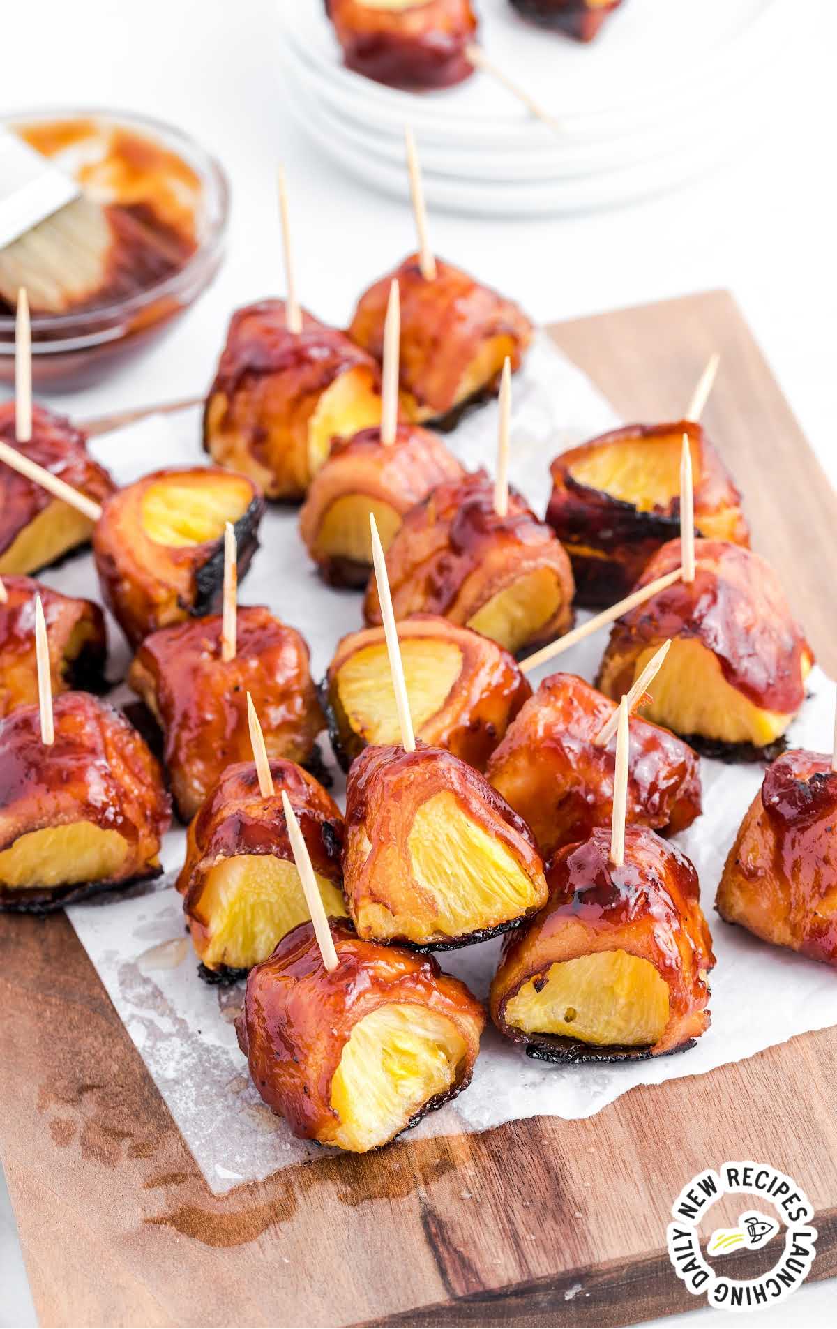 close up shot of Bacon-Wrapped Pineapple on a wooden board