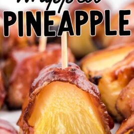 close up shot of Bacon-Wrapped Pineapple on a wooden board