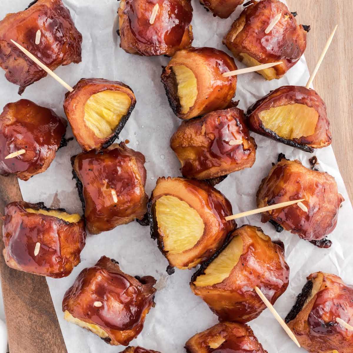 close up shot of Bacon-Wrapped Pineapple on a wooden board
