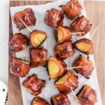 close up overhead shot of Bacon-Wrapped Pineapple on a wooden board