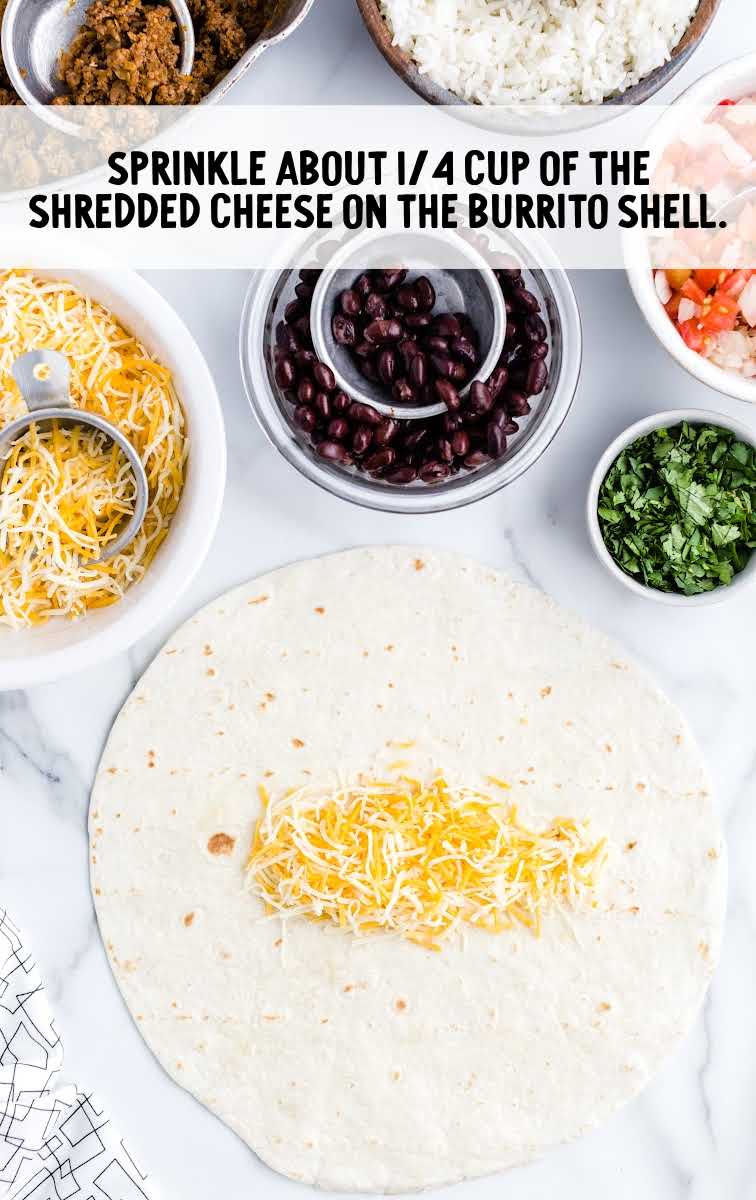 shredded cheese being placed on top of the tortilla