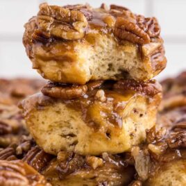 close up shot of Caramel Pecan Cinnamon Rolls stacked on top of each other