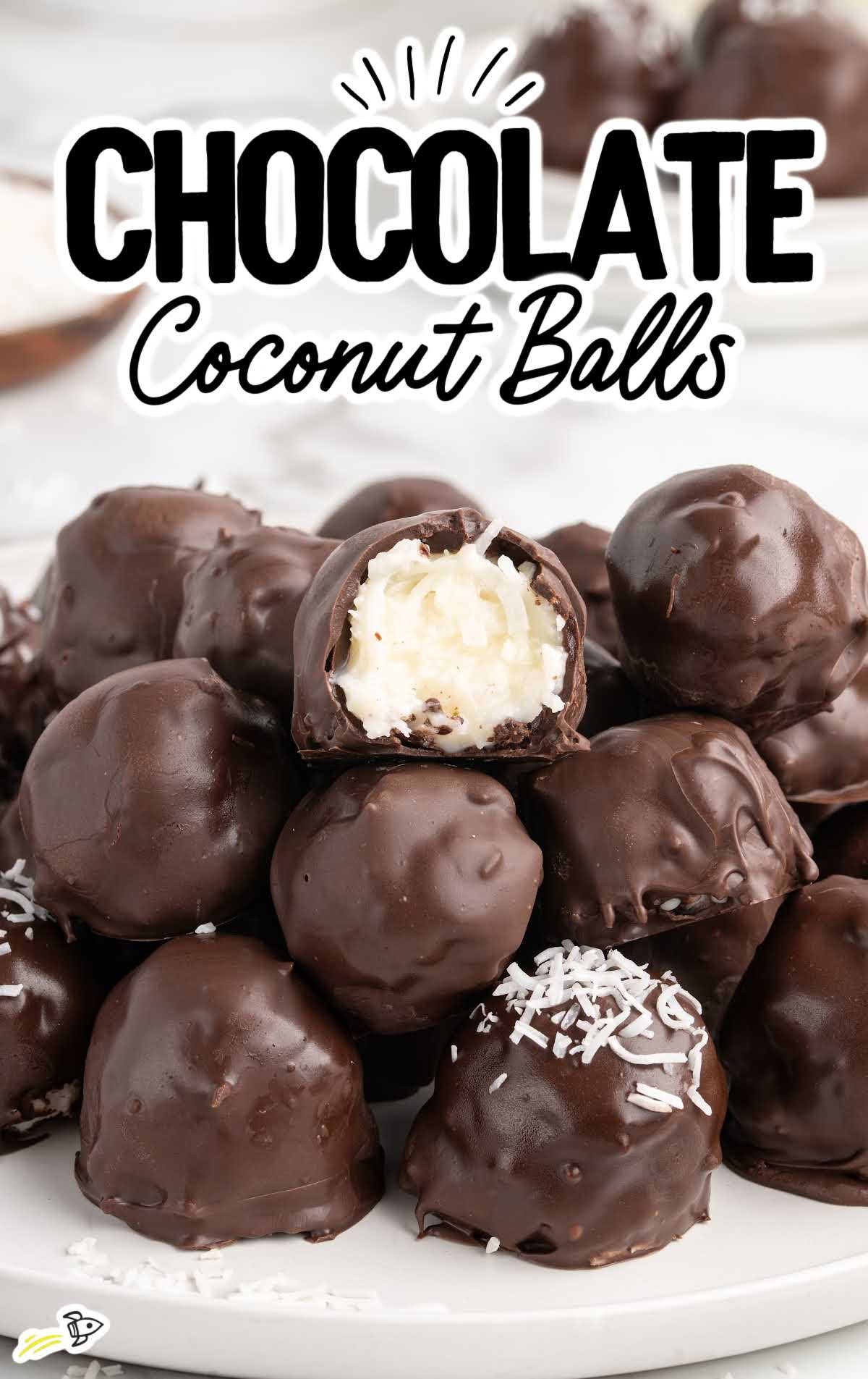 Stack of chocolate coconut balls with one cut open showing coconut center.