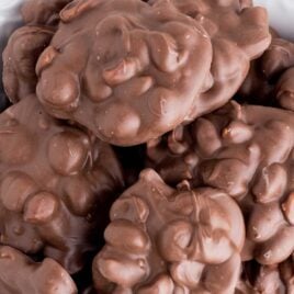 close up overhead shot of Chocolate Peanut Clusters piled on top of each other in a bowl
