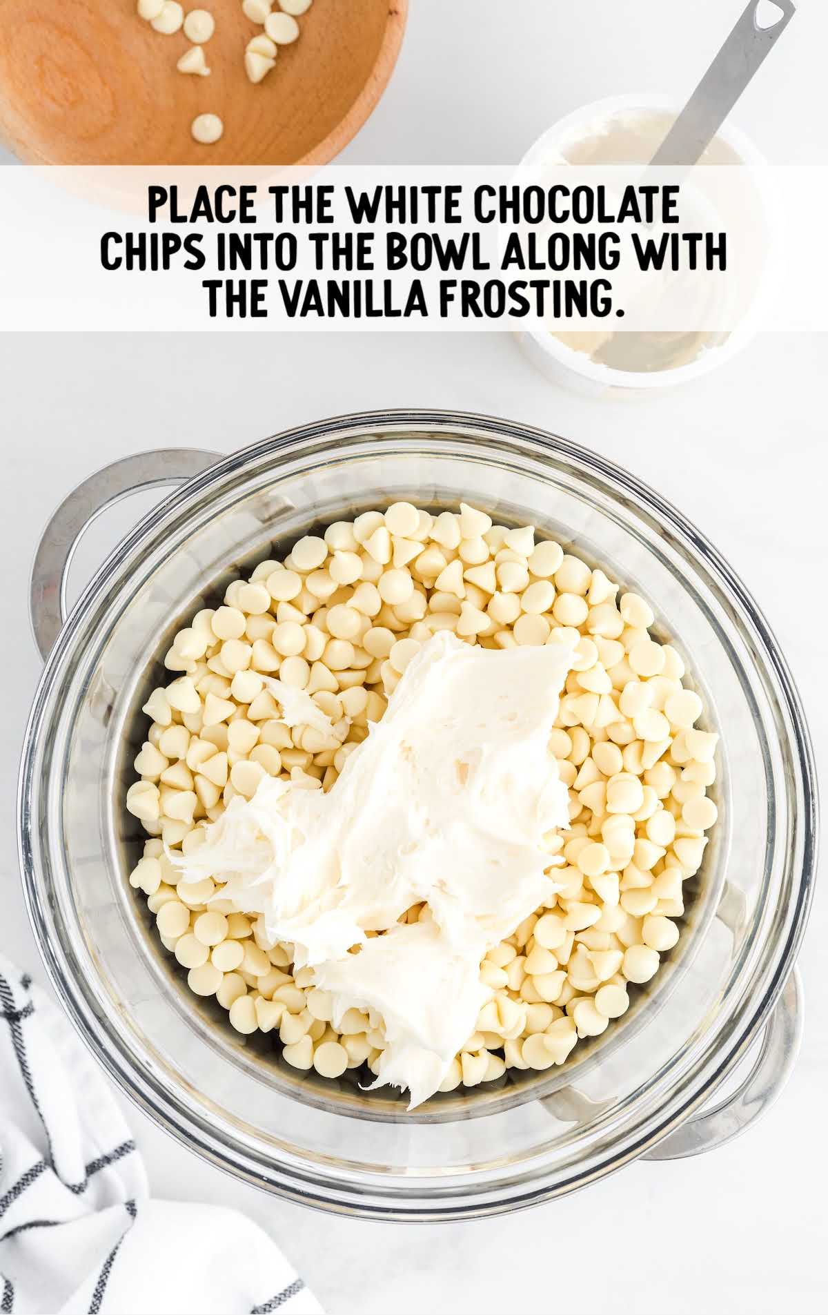 white chocolate chips placed into the bowl with the vanilla frosting 