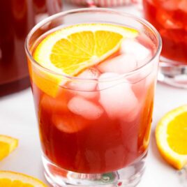 a glass of punch garnished with a orange slice