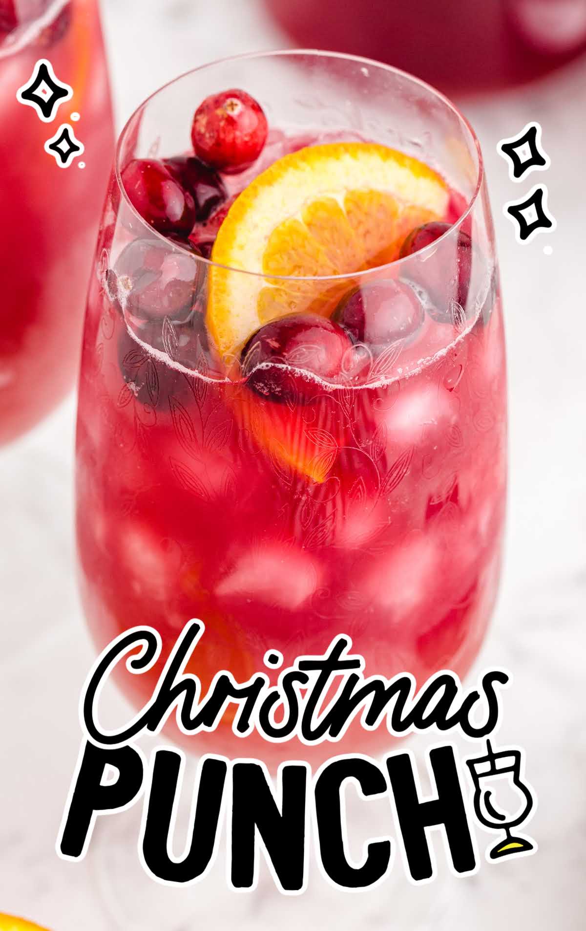 close up shot of a glass of Christmas Punch garnished with cranberries and a orange slice