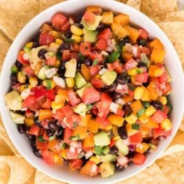 close up overhead shot of a bowl of Cowboy Caviar on top of a plate of tortilla chips