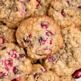 close up overhead shot of a plate piled with Cranberry Pecan Oatmeal Cookies and garnished with cranberries