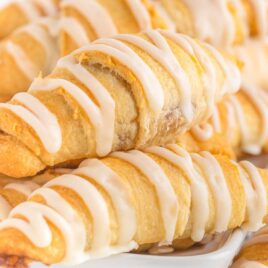 close up shot of a bunch of Crescent Roll Cinnamon Rolls drizzled with glaze