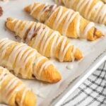 close up shot of a plate of Crescent Roll Cinnamon Rolls drizzled with glaze