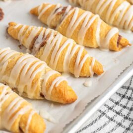 close up shot of a plate of Crescent Roll Cinnamon Rolls drizzled with glaze