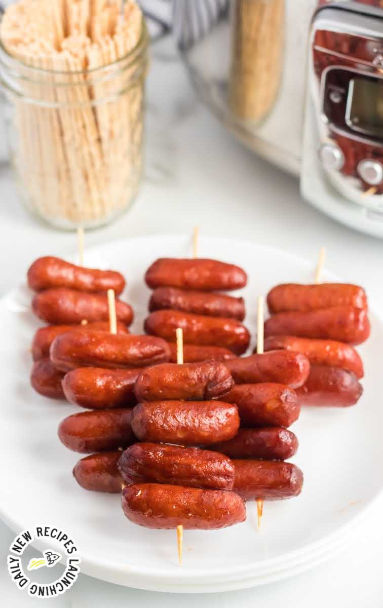 close up shot of a plate of Crockpot Little Smokies on skewers