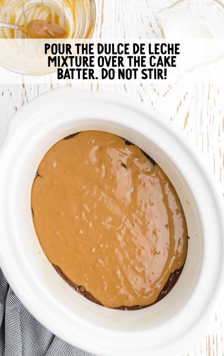dulce de leche poured on top of cake batter in the crockpot