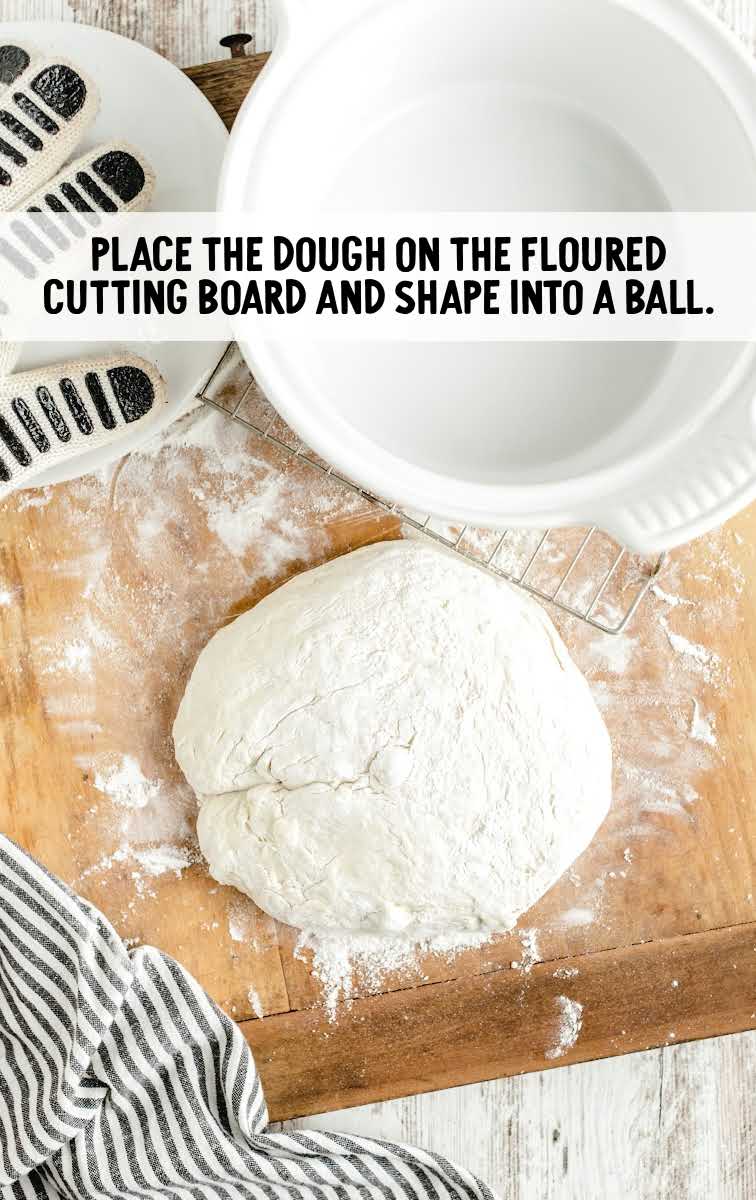dough floured on a cutting board and shaped into a ball