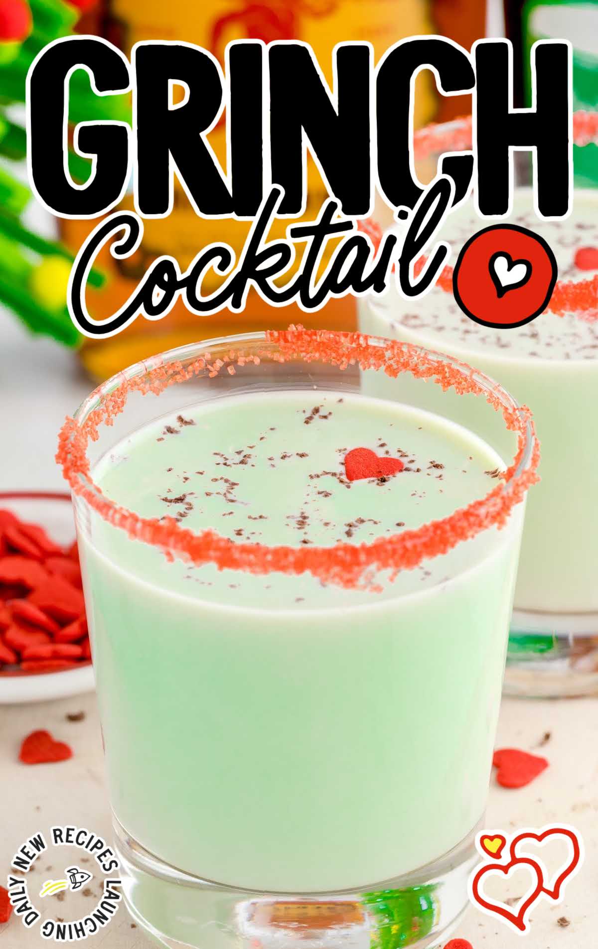 close up shot of a cocktail glass of Grinch Cocktail garnished with chocolate shaving and candy sprinkles