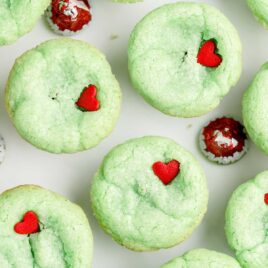 overhead shot of Grinch Stuffed Cookies topped with a heart candy sprinkle on a plate