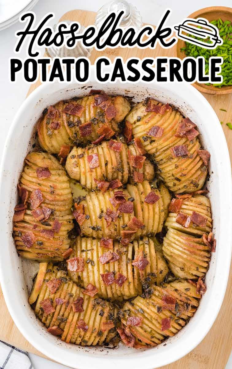 close up overhead shot of Hasselback Potato Casserole garnished with bacon bits and green onions in a baking dish