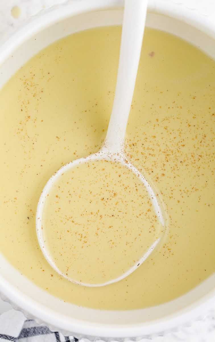 close up overhead shot of a large bowl of Homemade Eggnog with a spoon