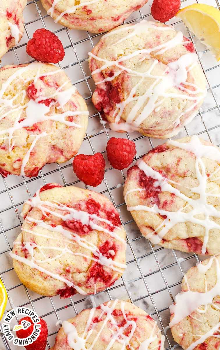 close up overhead shot of Lemon Raspberry Cookies garnished with lemon glaze on a cooling rack with raspberries