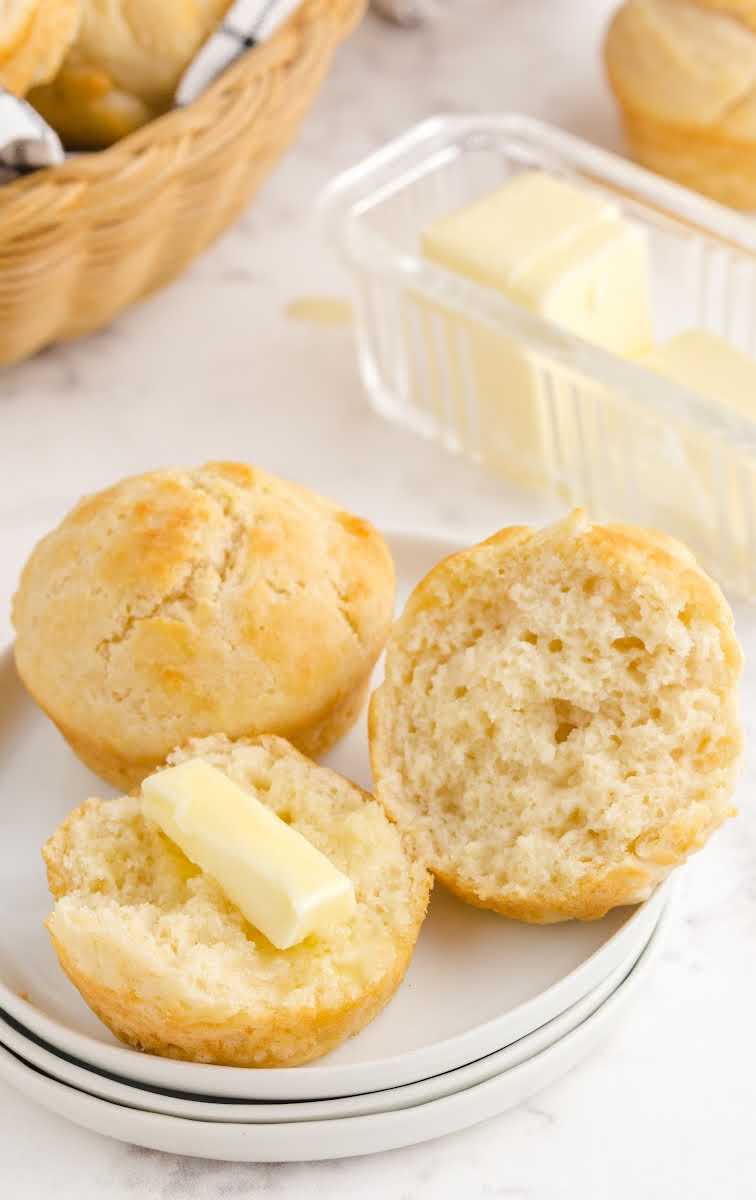 close up shot of No Yeast Dinner Rolls spread with butter on a plate