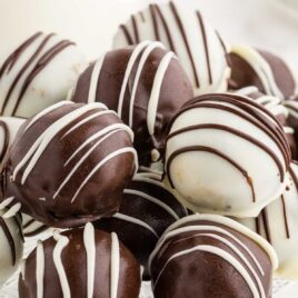close up shot of a serving tray of white chocolate Oreo Balls drizzled with chocolate and chocolate Oreo Balls drizzled with white chocolate
