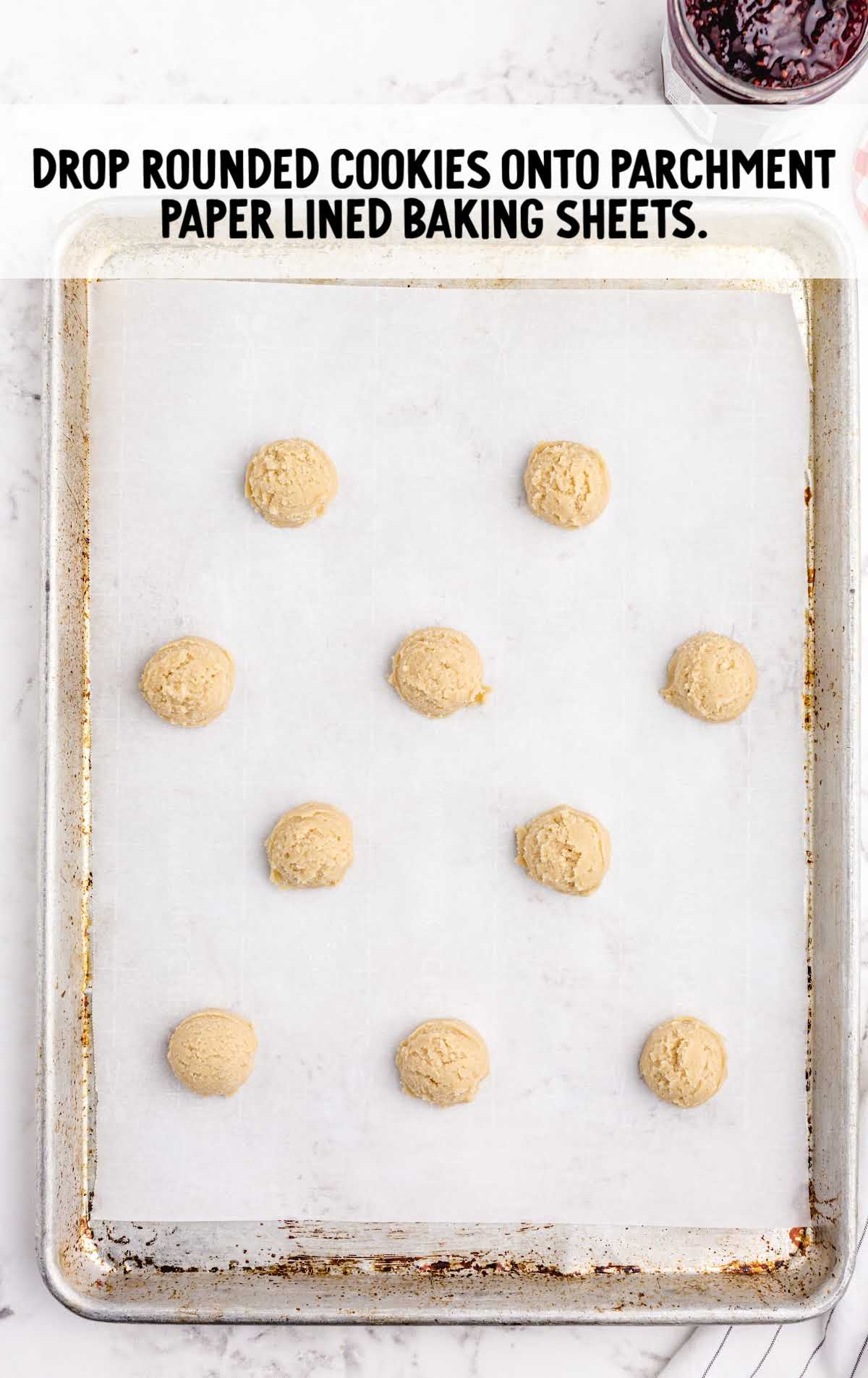 Thumbprint Cookies process shot of balls of cookie dough placed on a baking sheet