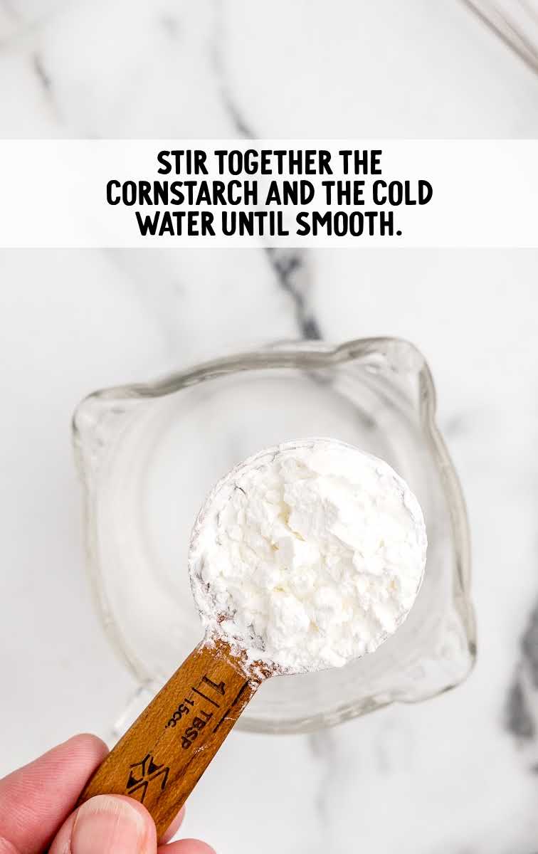 close up shot of cornstarch being added to cold water