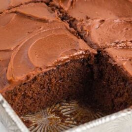 close up shot of chocolate cake recipe in a baking dish with a pice of cake missing