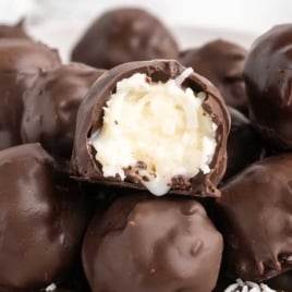 Close-up of chocolate coconut balls with creamy coconut filling inside.