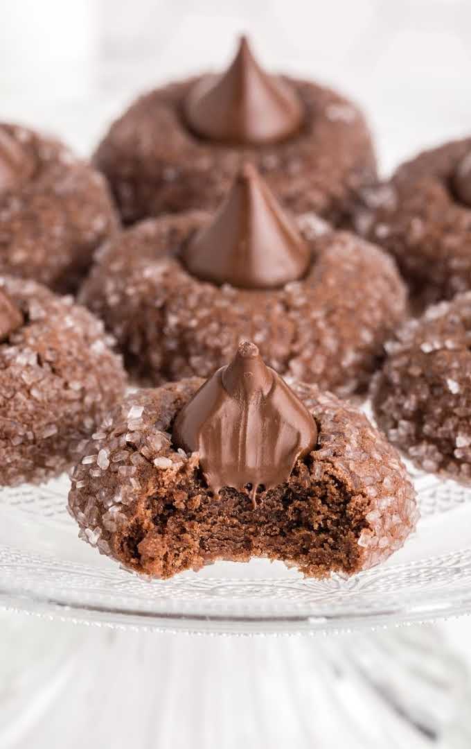 close up shot of a bunch of chocolate kiss cookies on a serving plate