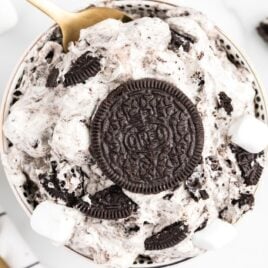 close up overhead shot of a bowl of oreo fluff topped Oreos and mini marshmallows with a spoon