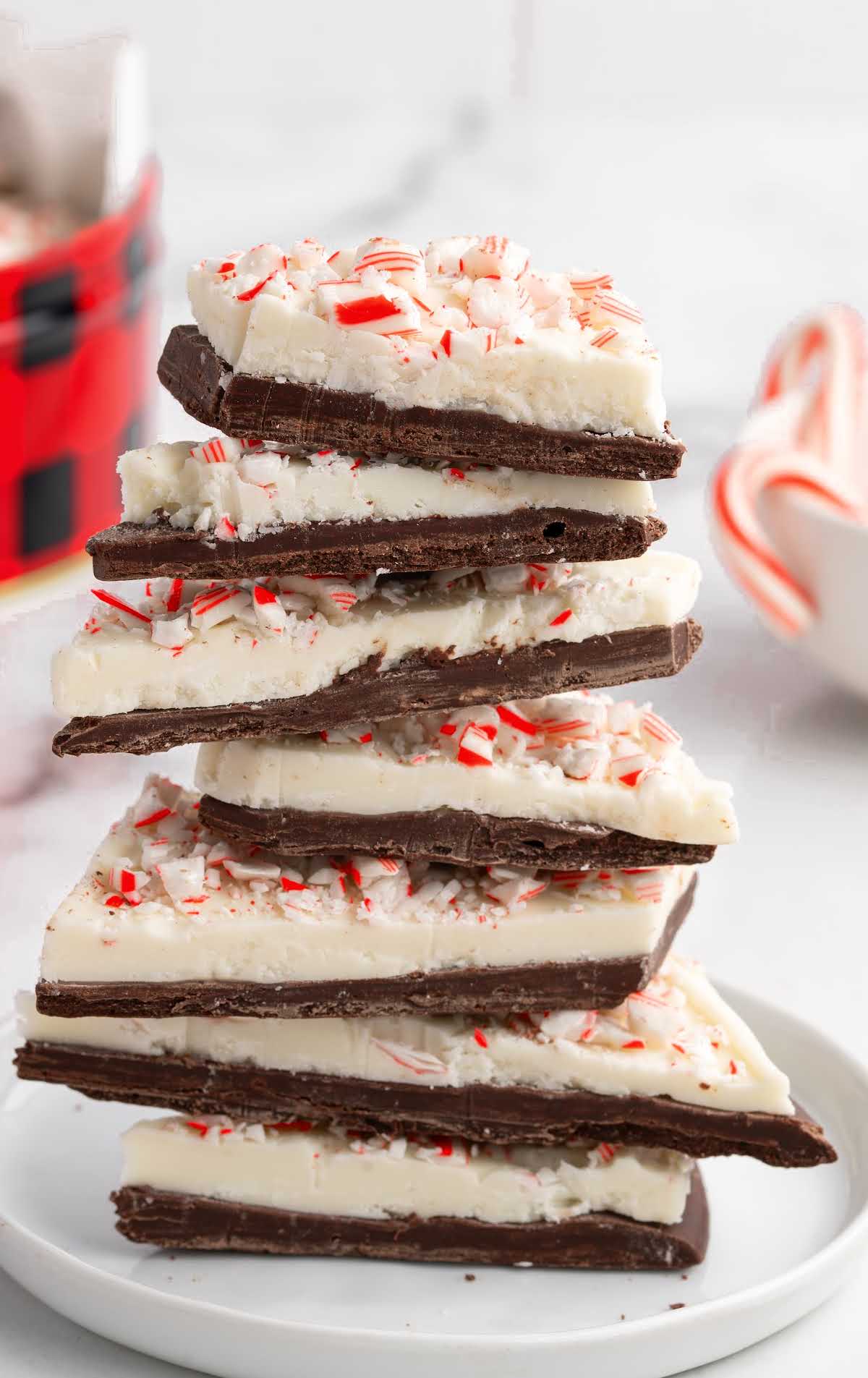 Stack of peppermint bark squares with white chocolate and candy cane topping