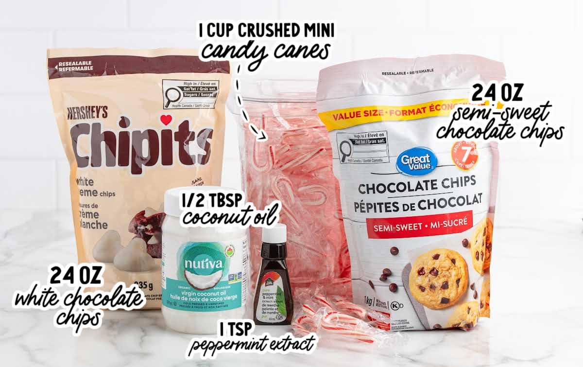 Peppermint bark ingredients including white chocolate chips, semi-sweet chocolate chips, candy canes, peppermint extract, and coconut oil