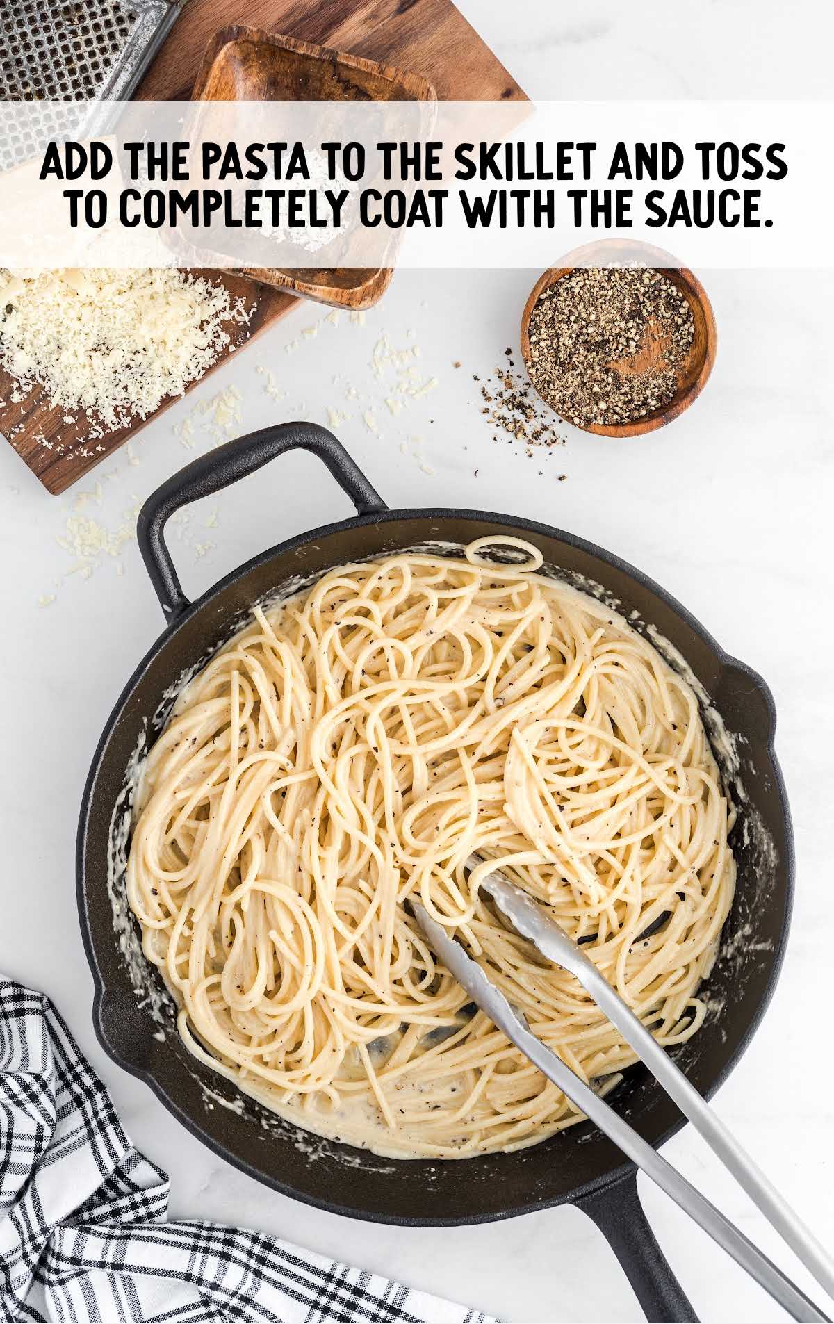 Cacio e Pepe process shot of pasta added to the skillet of sauce