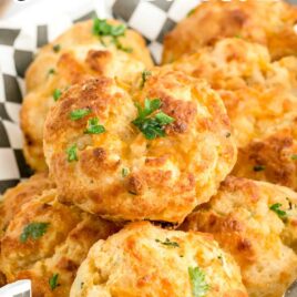 close up shot of a bunch of Copycat Red Lobster Biscuits garnished with parsley in a basket