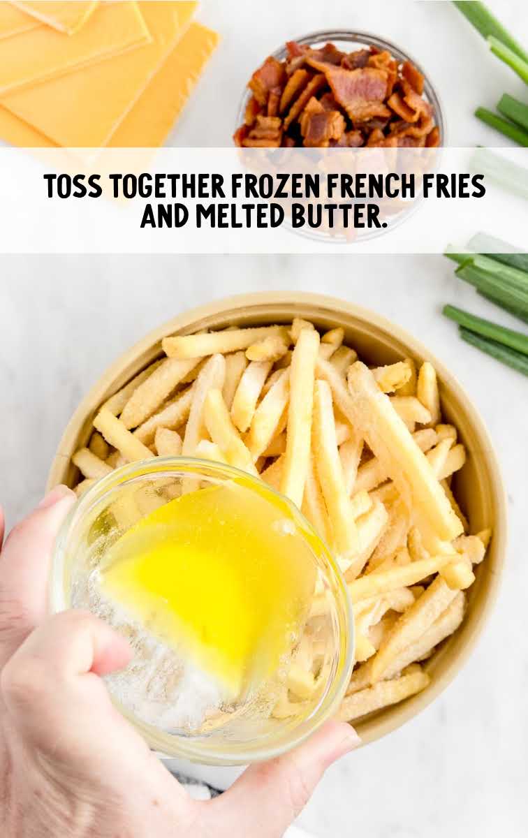 French fries and melted butter tossed together in a bowl