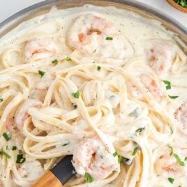 close up overhead shot of a pot of Shrimp Alfredo topped with parsley