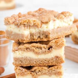 close up shot of snickerdoodle cheesecake bars stacked on top of each other