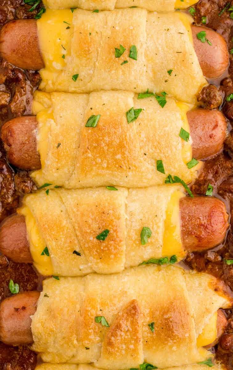 close up overhead shot of a baking dish of chili cheese dog bake garnished with parsley