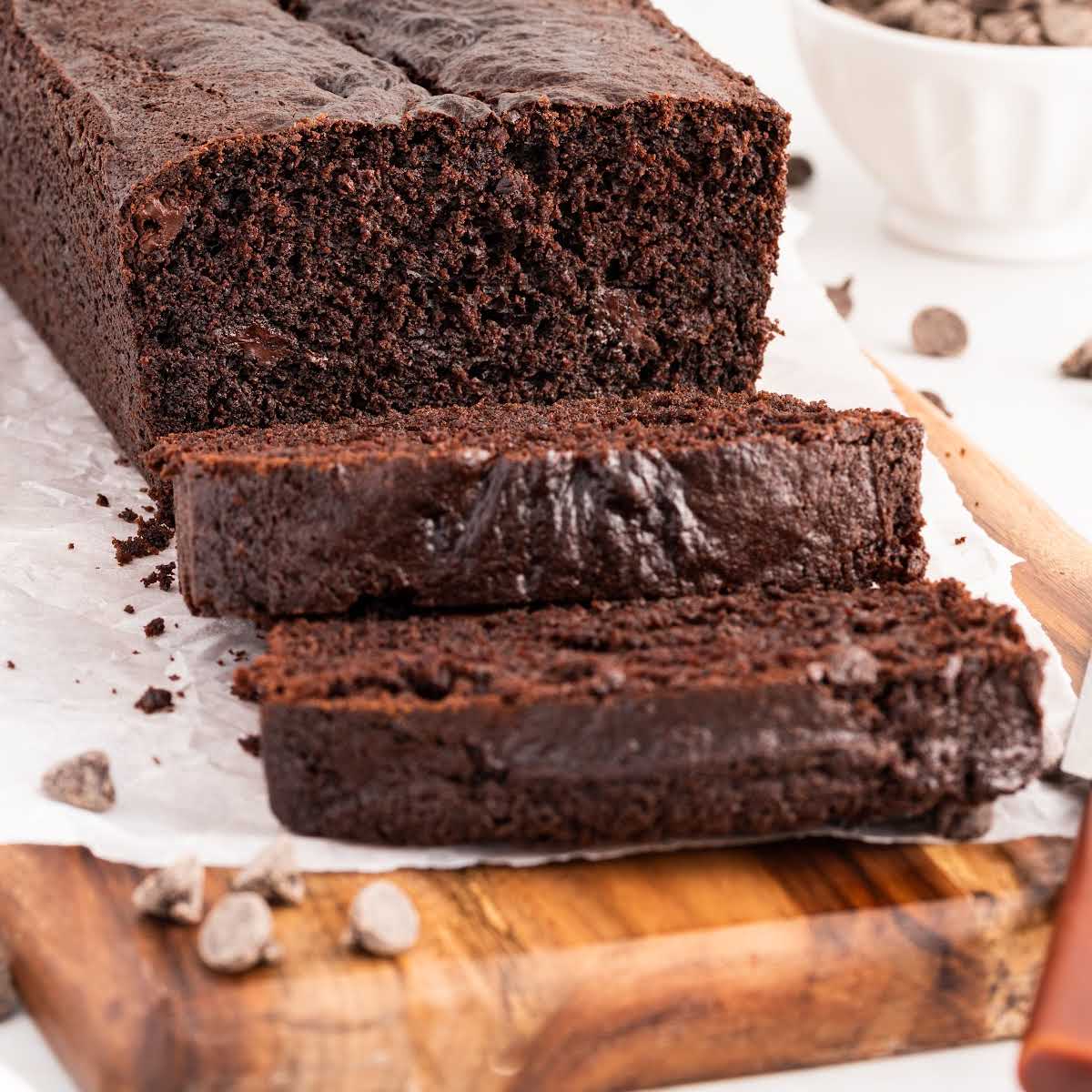 close up shot of a loaf of Chocolate Bread with slices taken off on a wooden board