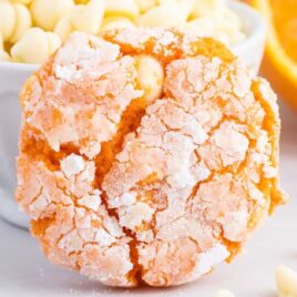 close up shot of Creamsicle Cookies in front of a bowl of white chocolate chips and a slice of orange