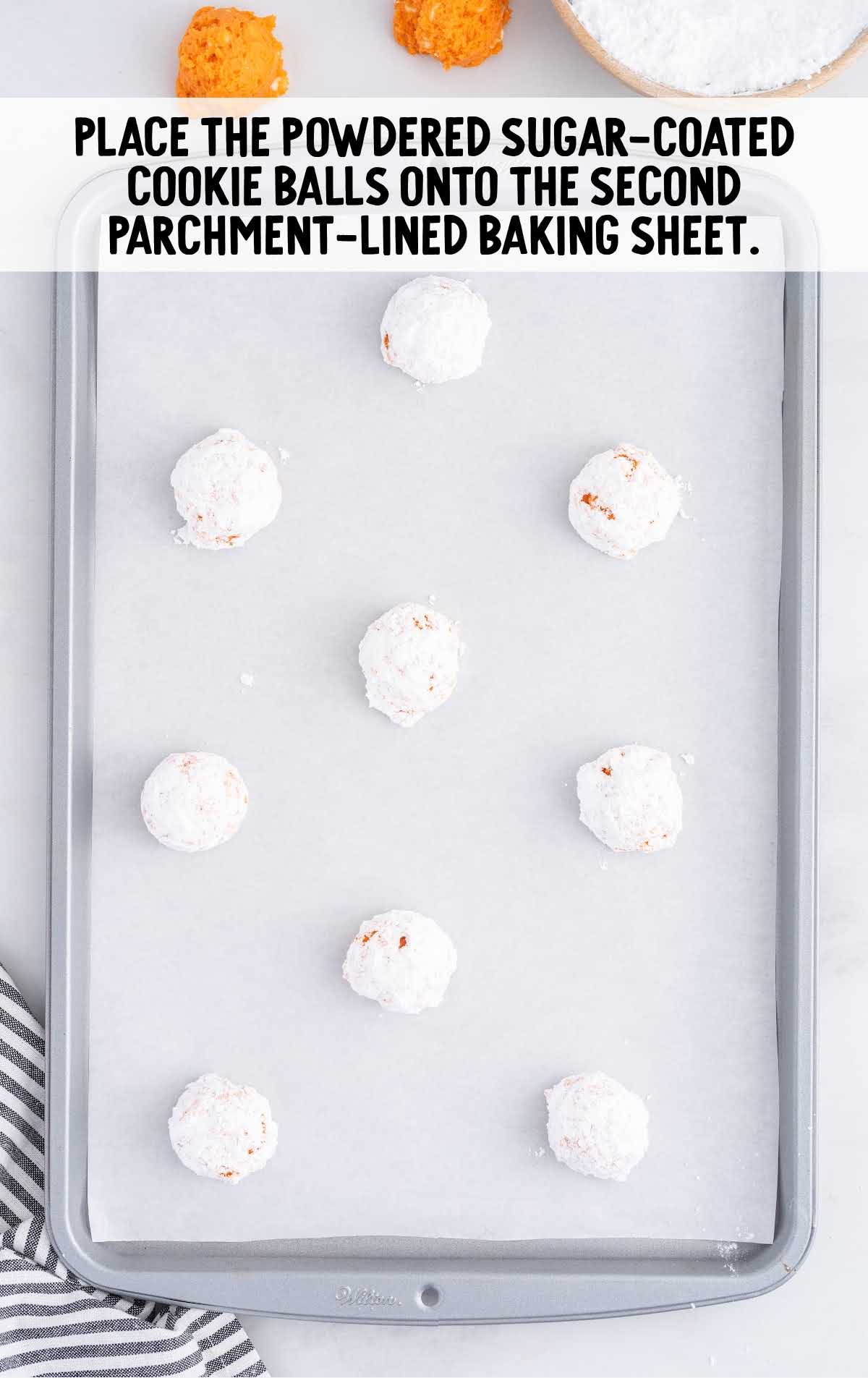 Creamsicle Cookies process shot of powered sugar coated cookie balls placed on a baking sheet
